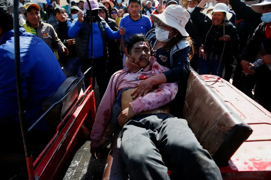 Manifestantes ajudam um homem ferido durante um confronto com as forças de segurança na segunda-feira em Juliaca.Crédito...